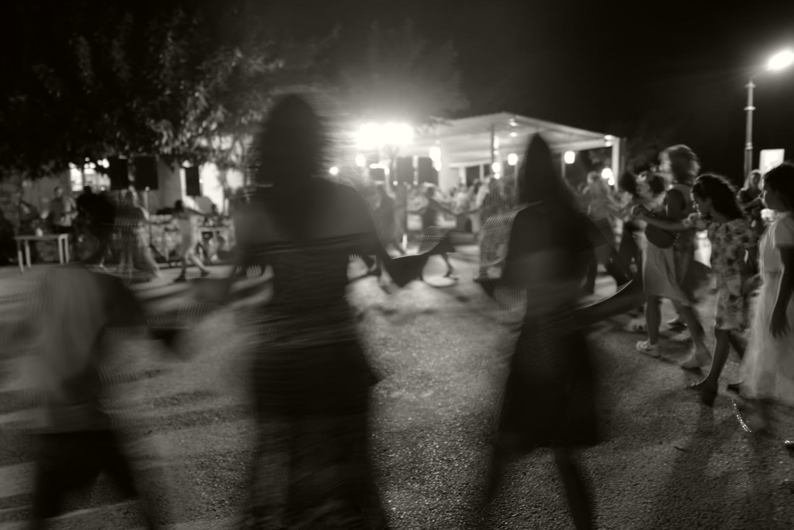 Blurred figures dancing in a circle at night